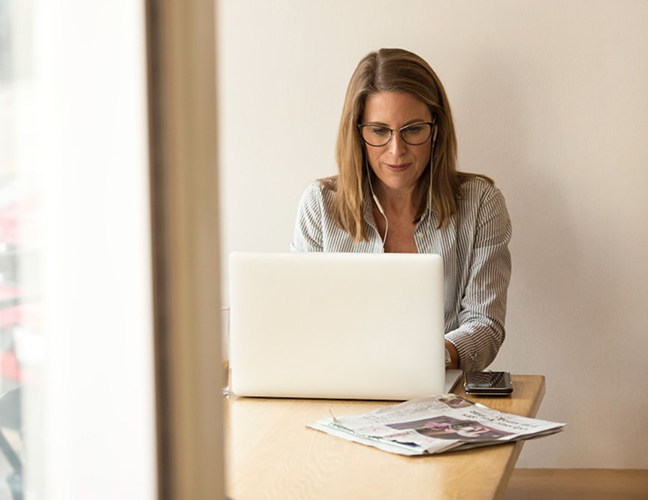 Woman with glasses looking at laptop
