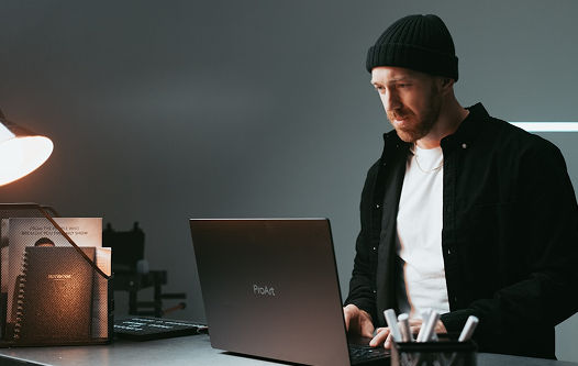 Man in beanie looking at laptop